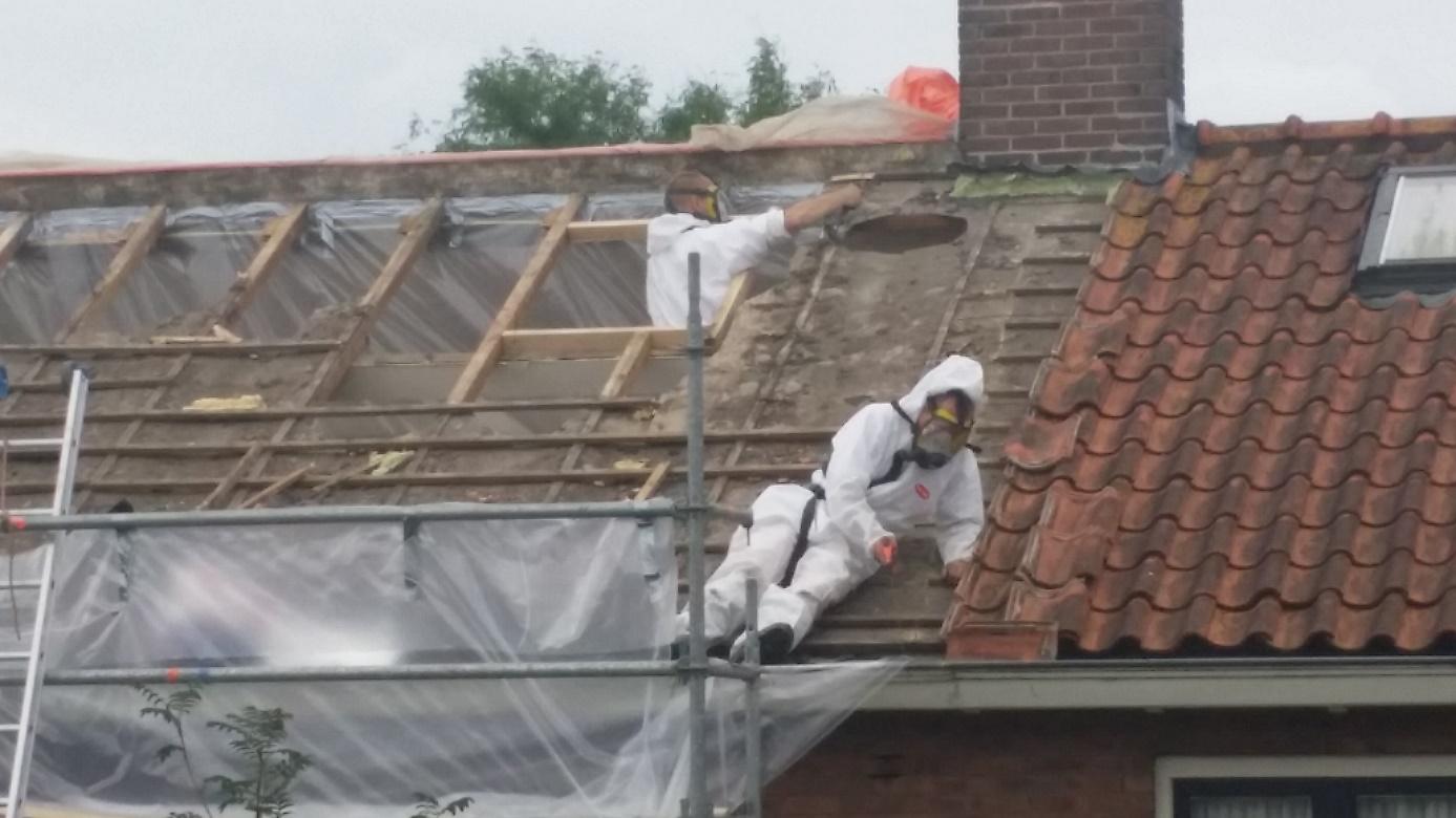 Wimmie in wit pak als asbestsaneerder aan het werk op het dak